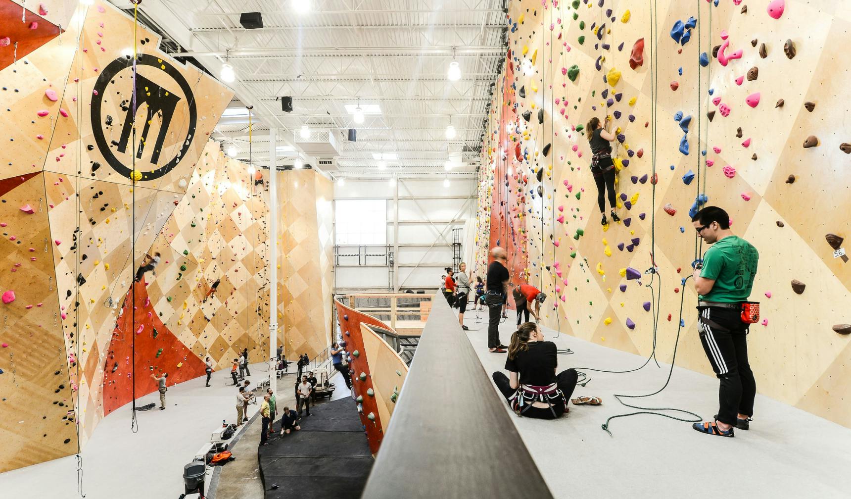 Two-story indoor climbing gym full of people