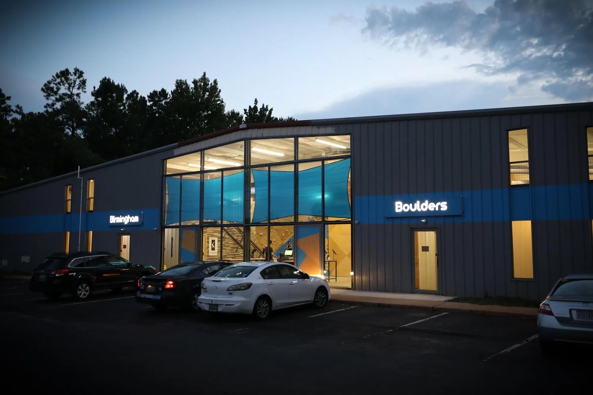 An exterior view just before dark shows the inviting design of this building's appearance, as well as how consistently branded the whole facility is. Its also easy to see where all of their natural light comes from.