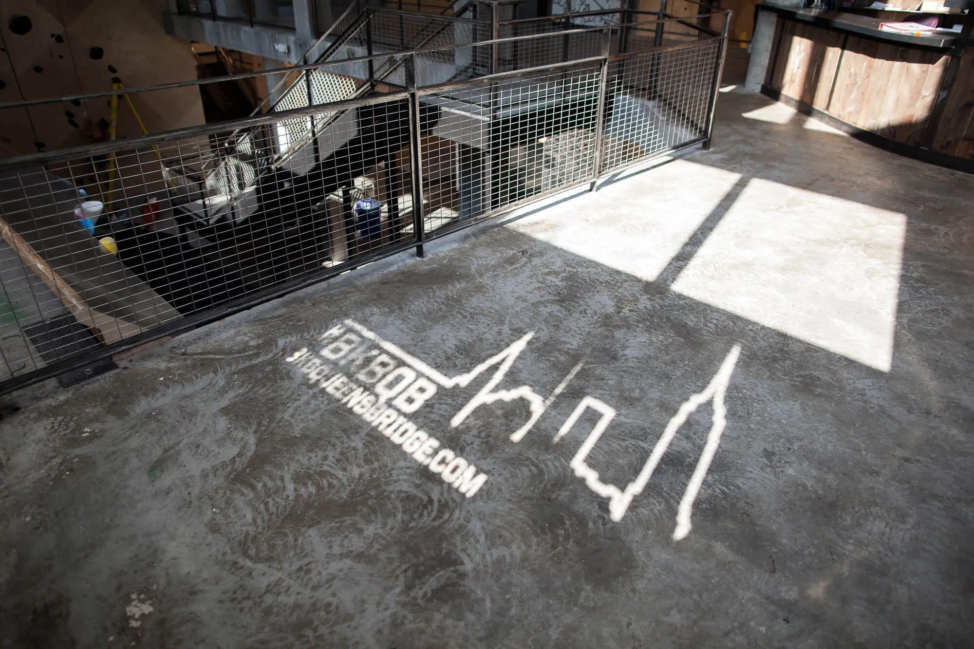 The exterior design of the graphics covering the ground-level windows allow BKB branded logos to shine through and project onto interior surfaces.