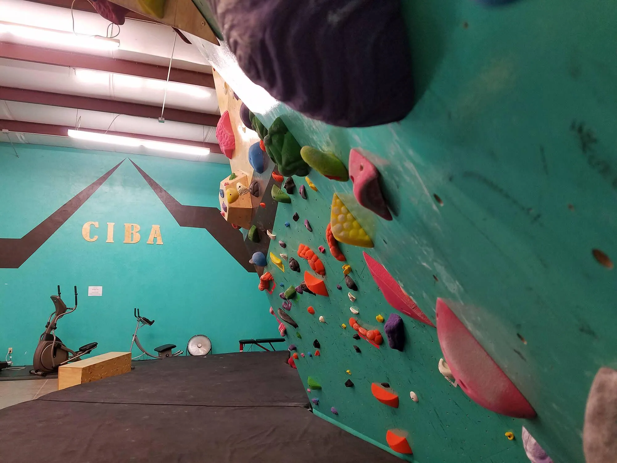 A climbing wall close-up at the gym showing some details on the branding and custom paint and logos used in the climbing gym build.