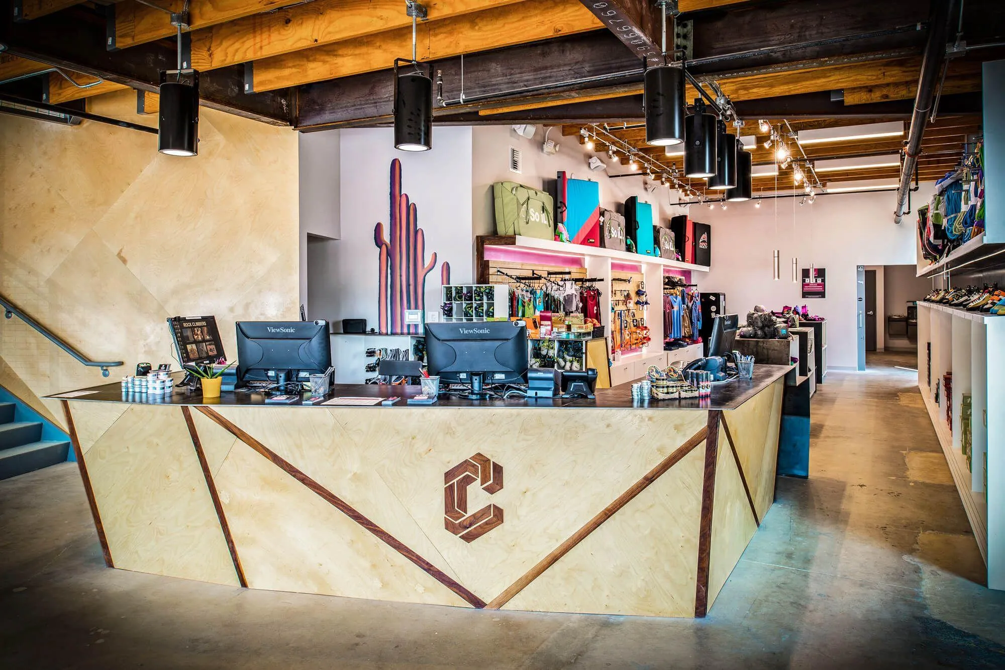 The front desk area with the retail shop in the background. The front desk boats some beautiful hardwood logo treatment and sets the tone for climbers entering their facility on what kind of quality product to expect beyond the entrance.