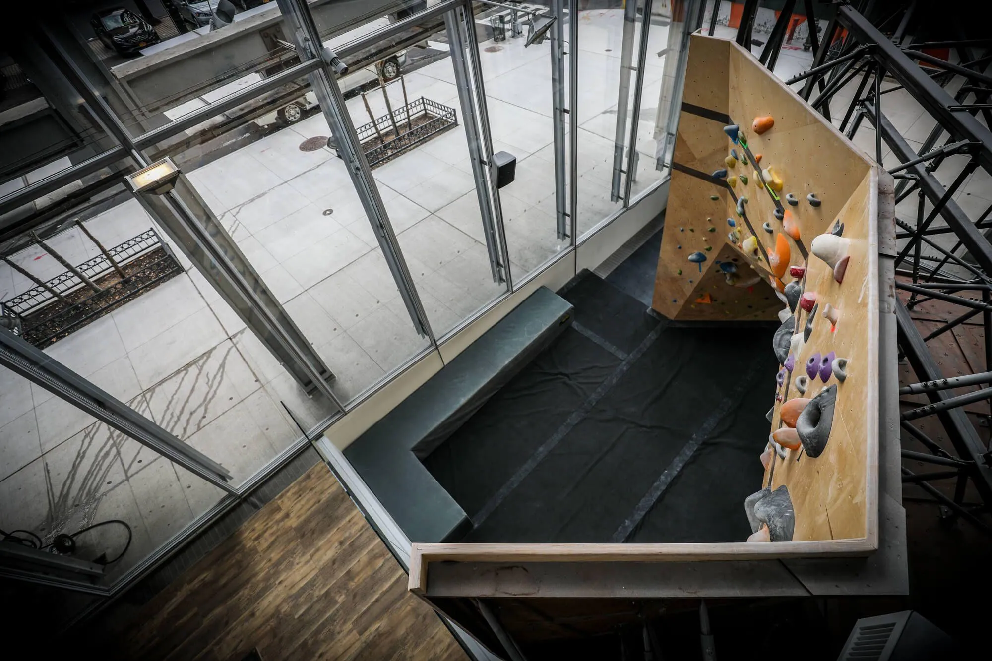Looking from the mezzanine downstairs at the backside of the bouldering cave below. Owner Michael Cesari wanted to carry his bouldering-specific brand's authenticity over to this new location while simultaneously creating something visually stunning from the outside to make use of the buildings impressive glass exterior.
