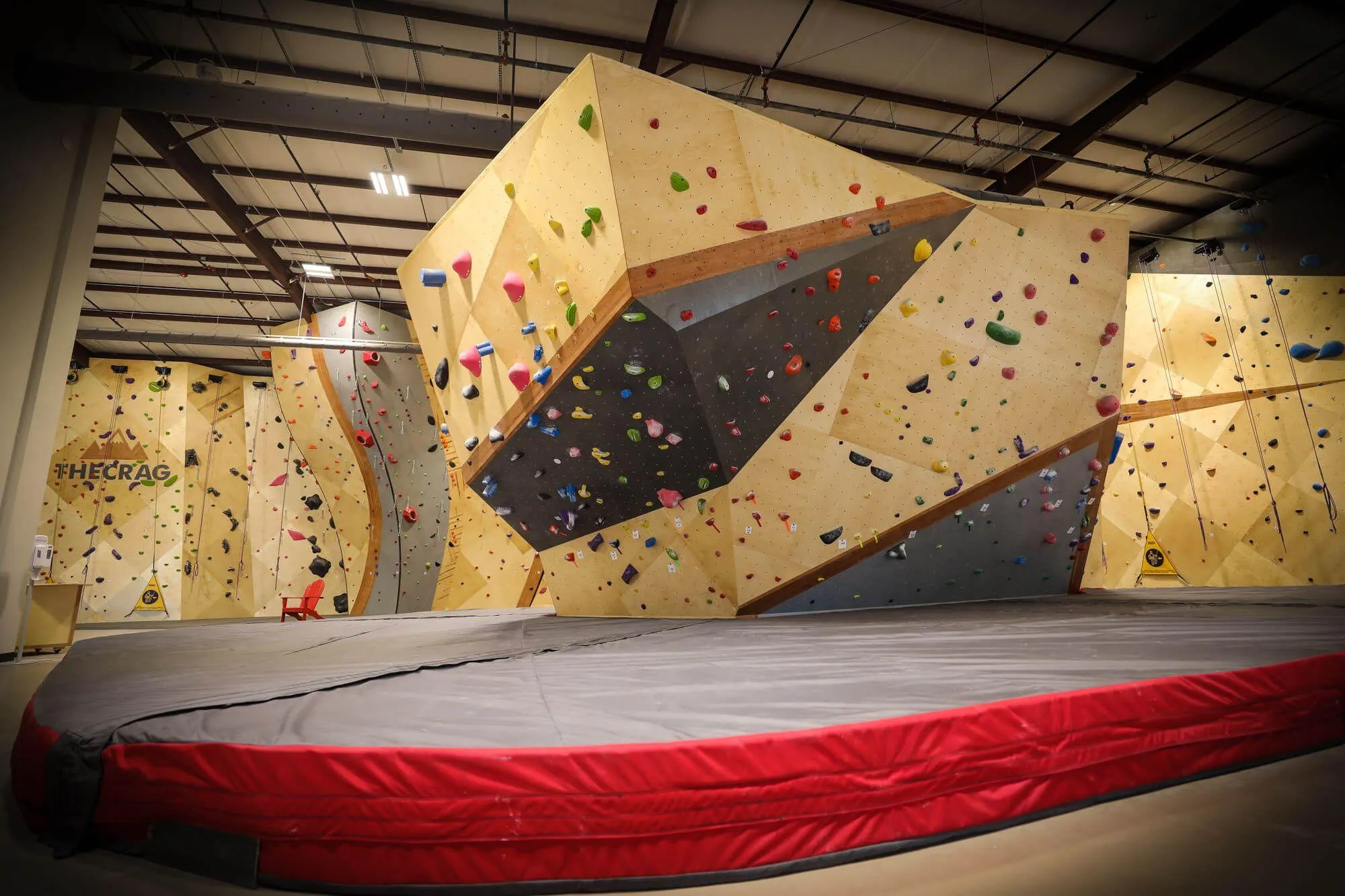 Another wide-angle view of the spacious climbing areas here in this gym, with the main boulder in the foreground. Don't let the clammer fool you, this overhung area is steeper than it looks, given the camera is only inches above the custom-branded Habit bouldering floor.