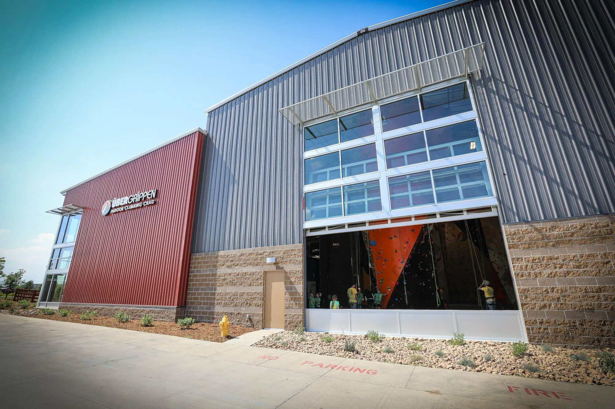 One side of the impressive outside design of the climbing gym, complete with large scale garage door allowing gobs of fresh air to enter on pleasant days and tons of sunlight during winter.