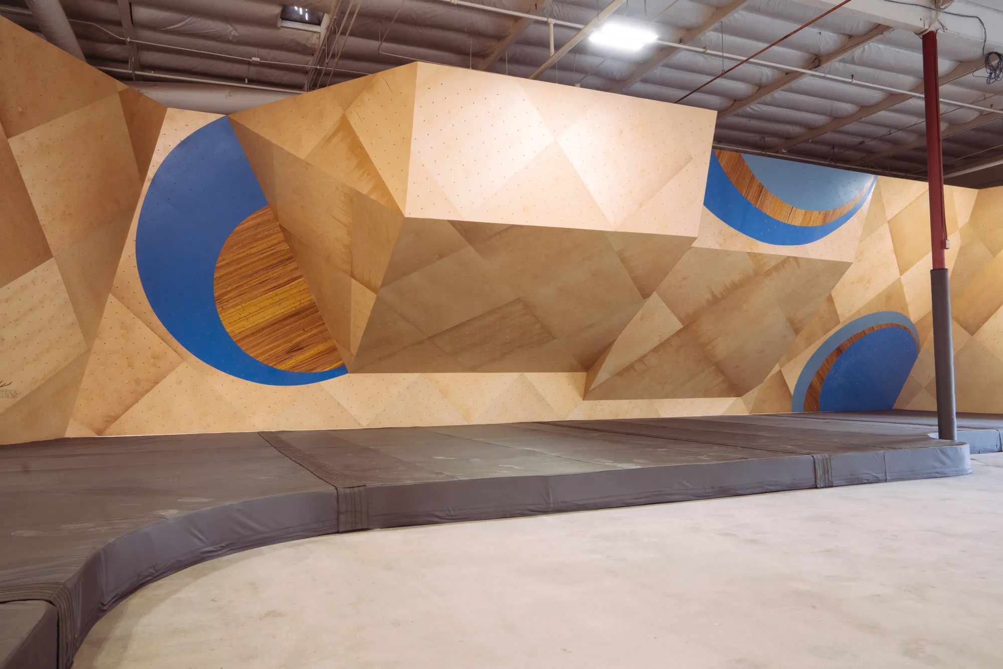 Bouldering pads installed under custom climbing walls